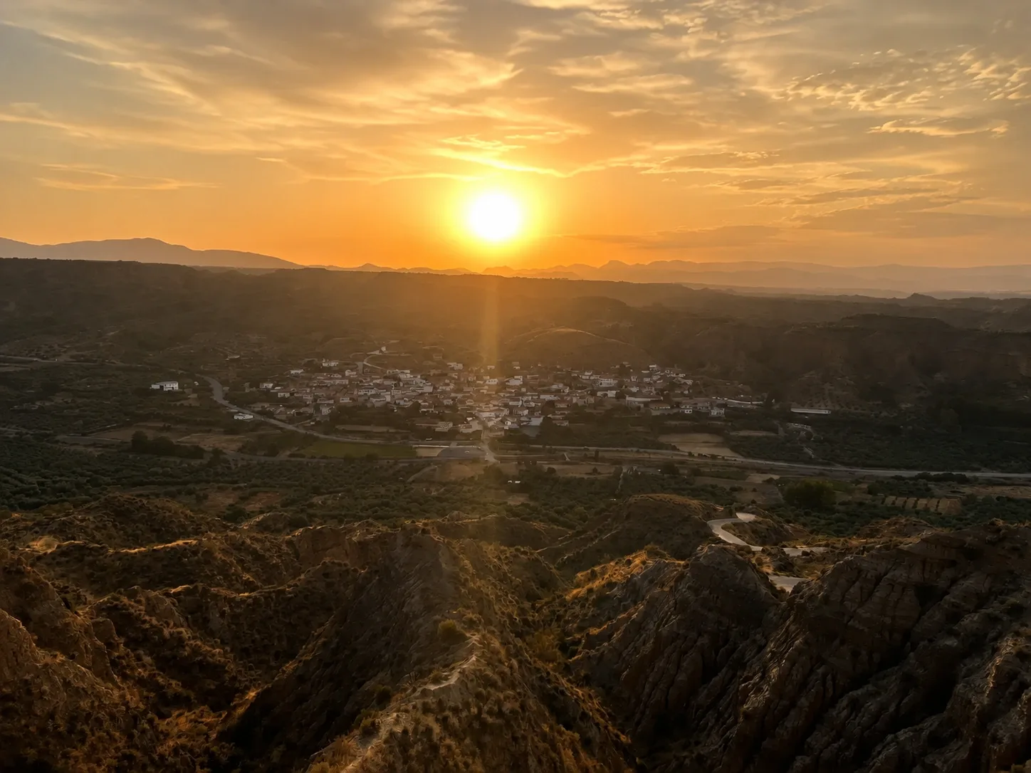 Cárcavas y pueblo desde el Fin del Mundo al atardecer