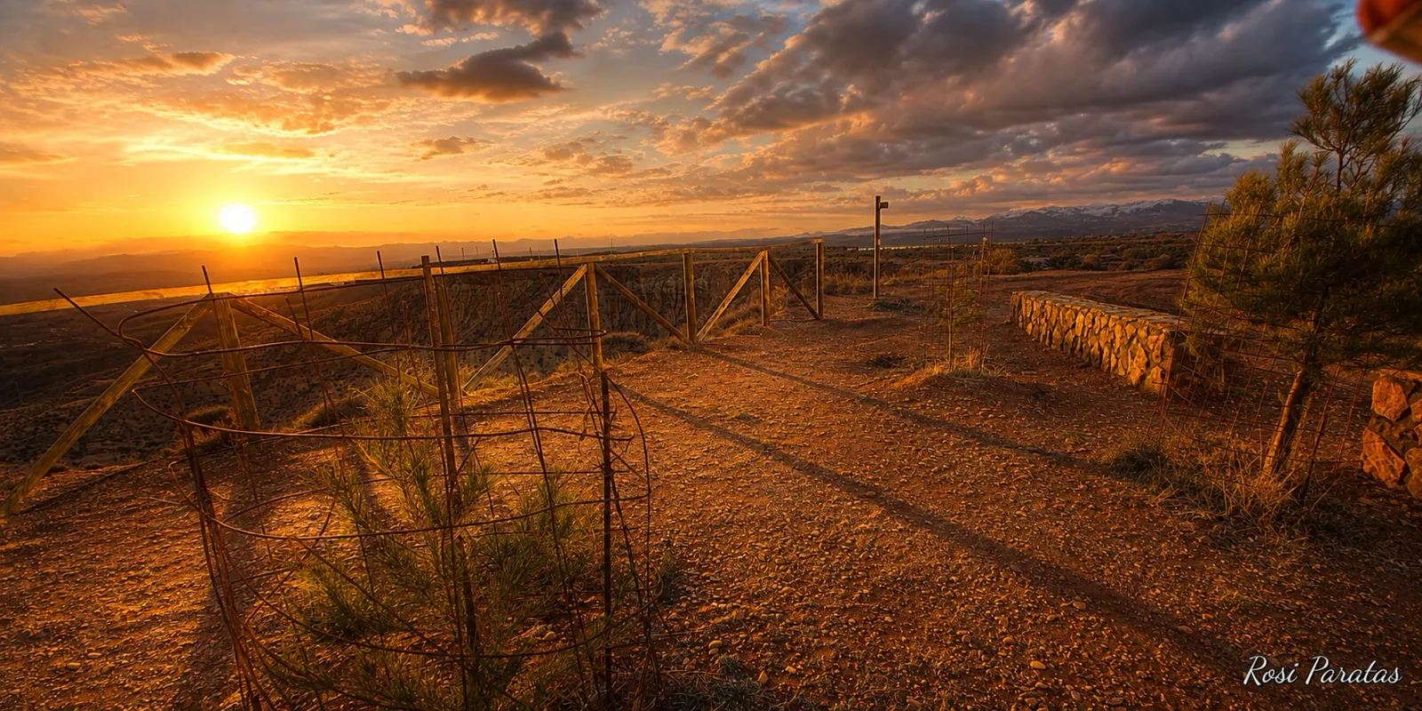 Sendero y vallado del mirador bajo la luz naranja del ocaso