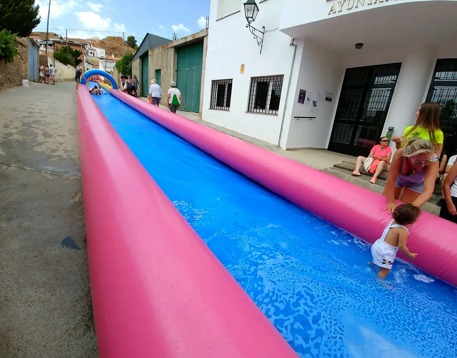 Niños jugando con una pista de agua durante las fiestas de San Lorenzo