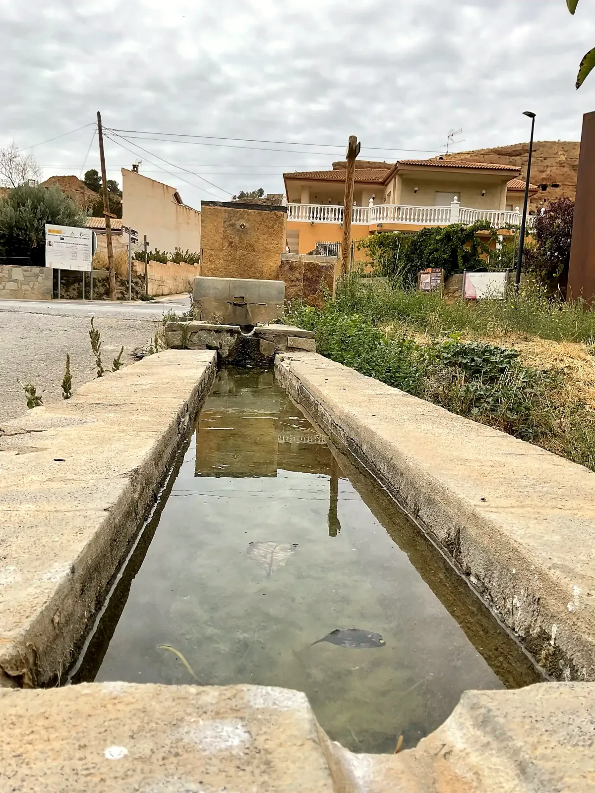 Vista longitudinal de la pila del abrevadero hacia su fuente en la entrada de Beas