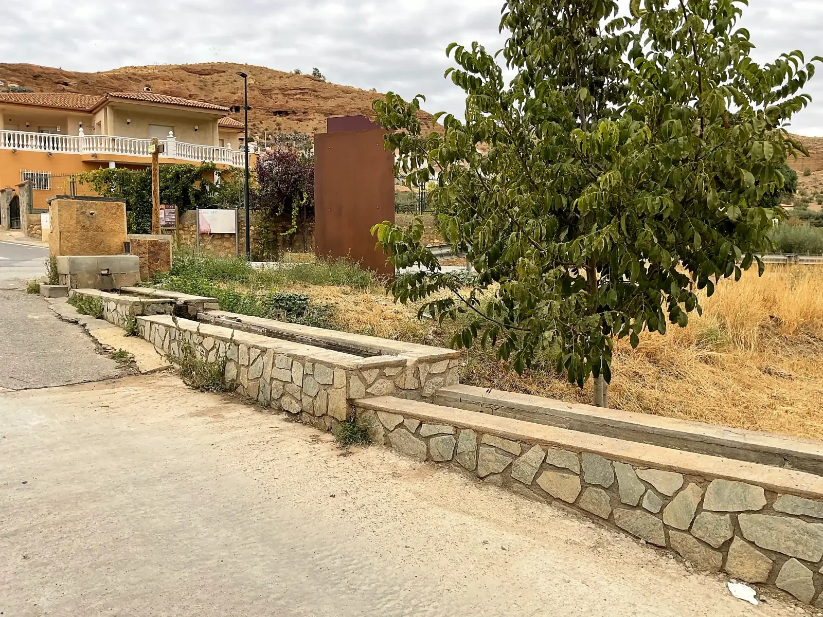 Vista general del abrevadero, su pila y el entorno de la entrada de Beas