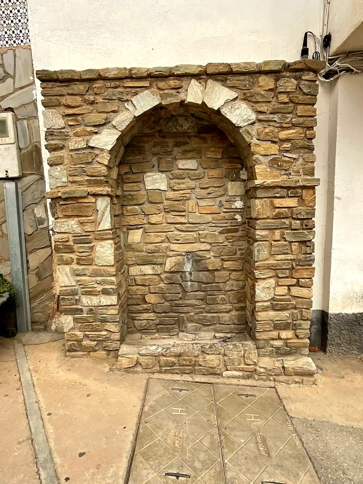 Fuente de piedra integrada en una fachada de la plaza de Beas