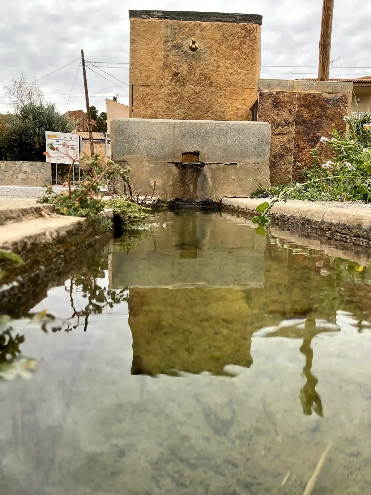 Fuente y pila del abrevadero de la entrada de Beas reflejadas en el agua