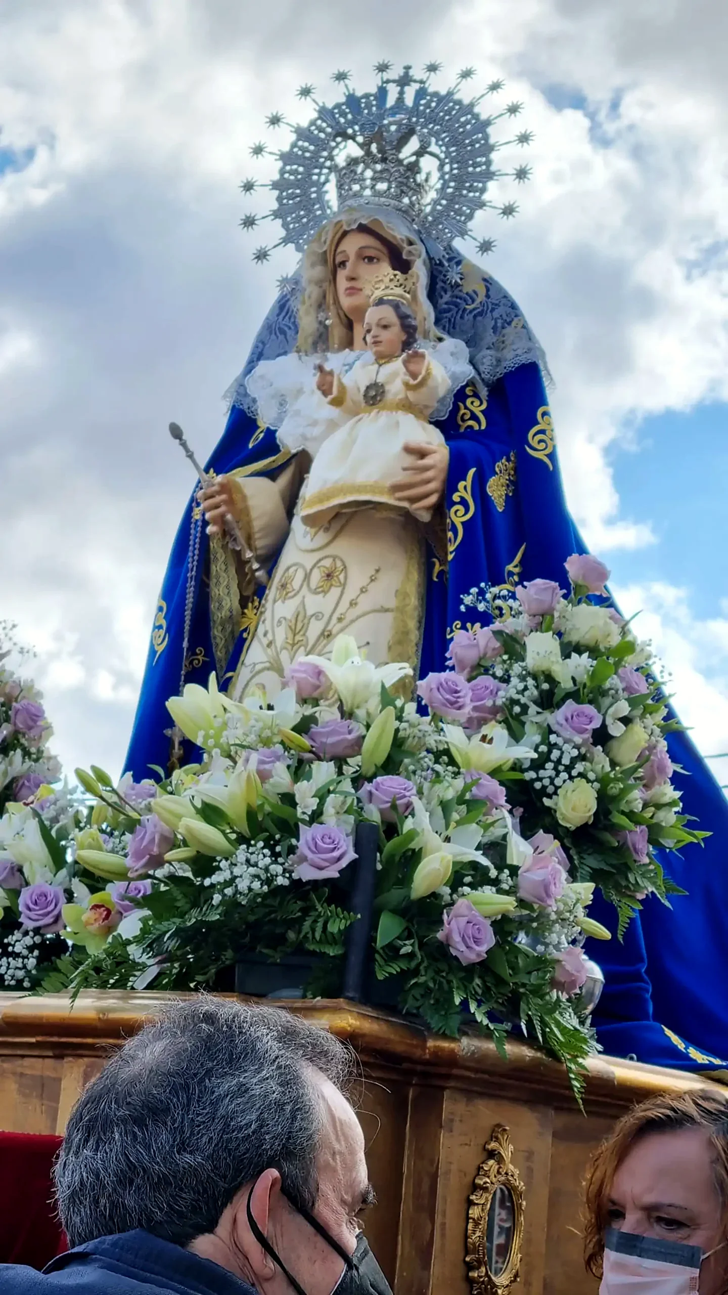Detalle de la Virgen de la Paz entre flores blancas y lilas