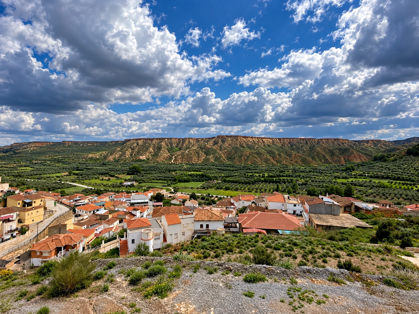 Casas de Beas de Guadix y la línea elevada de El Llano bajo grandes nubes