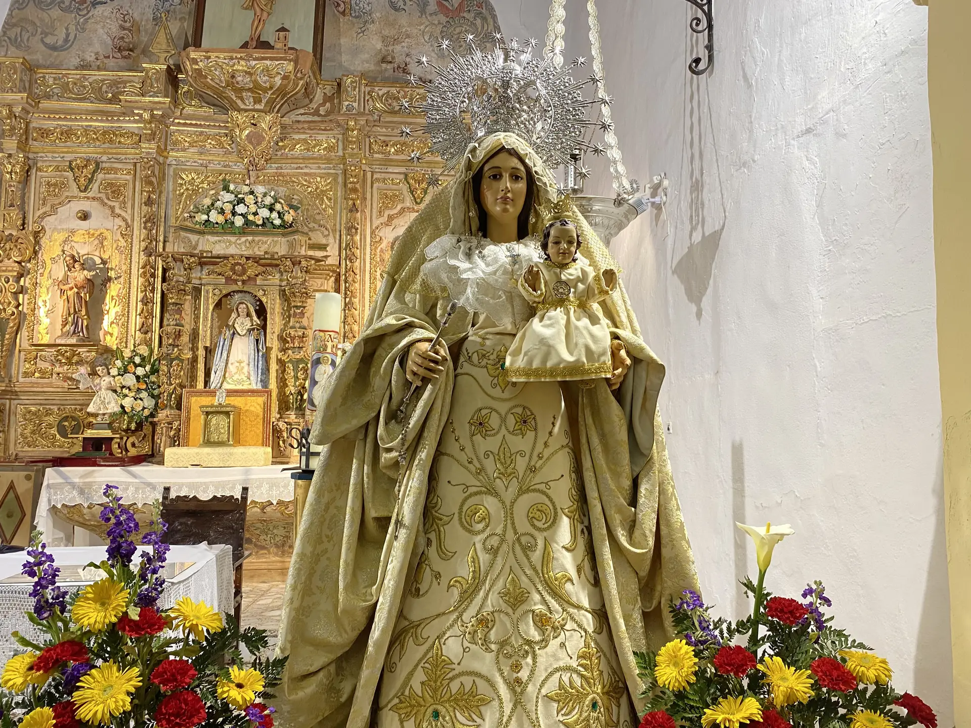 Imagen procesional de la Virgen de la Paz vestida con manto bordado y ráfaga de plata
