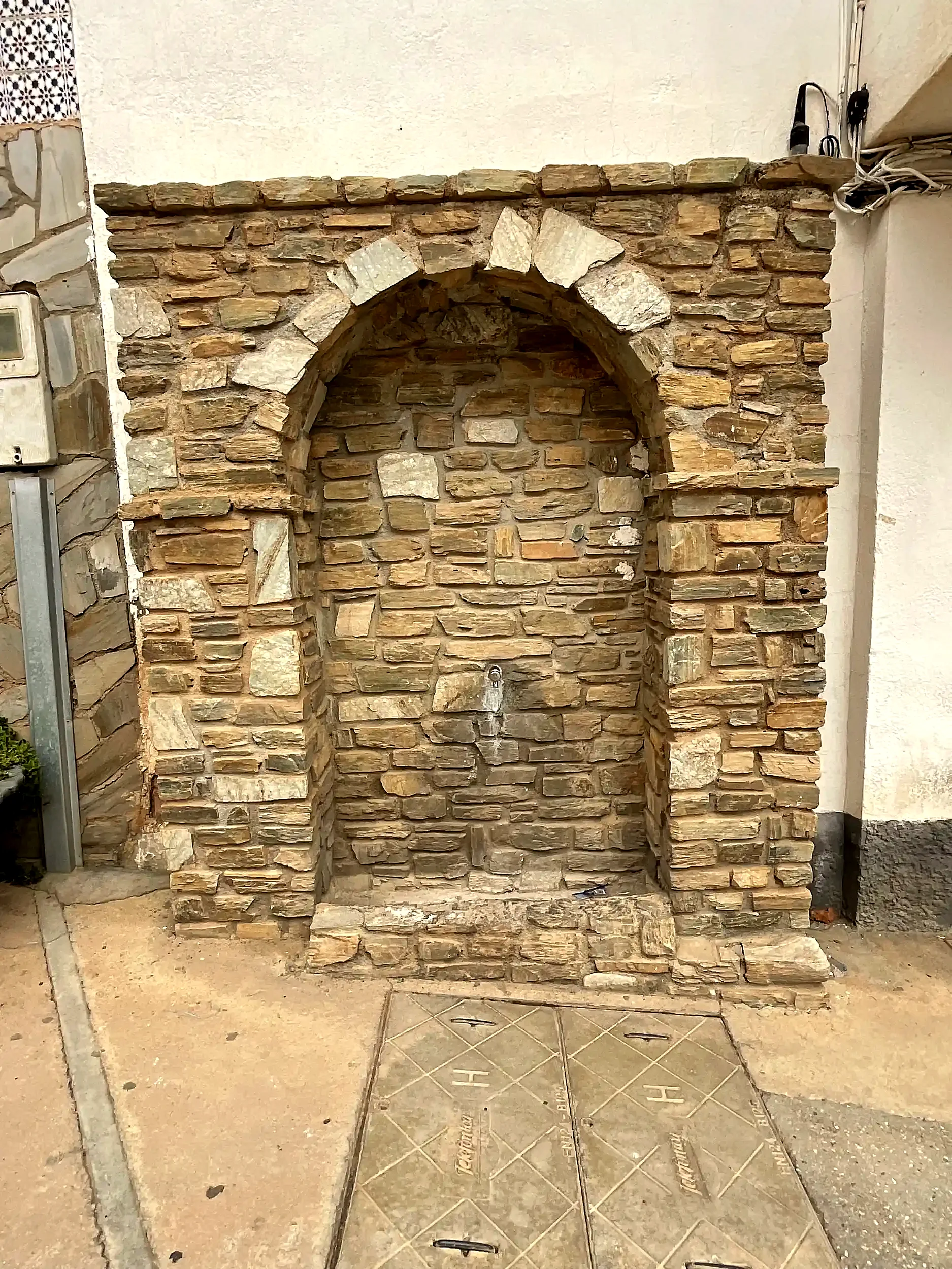 Fuente de piedra integrada en una fachada de la plaza de Beas